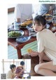 A woman sitting at a table with plates of food.