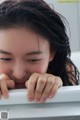 A young woman leaning over the edge of a bathtub.