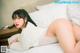 A woman laying on top of a bed in a white sweater.