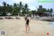 A woman in a black bathing suit standing on a beach.