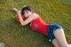 A woman laying on the grass with a basketball.