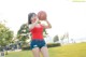 A woman holding a basketball in a park.