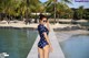 A woman in a polka dot swimsuit standing on a dock.